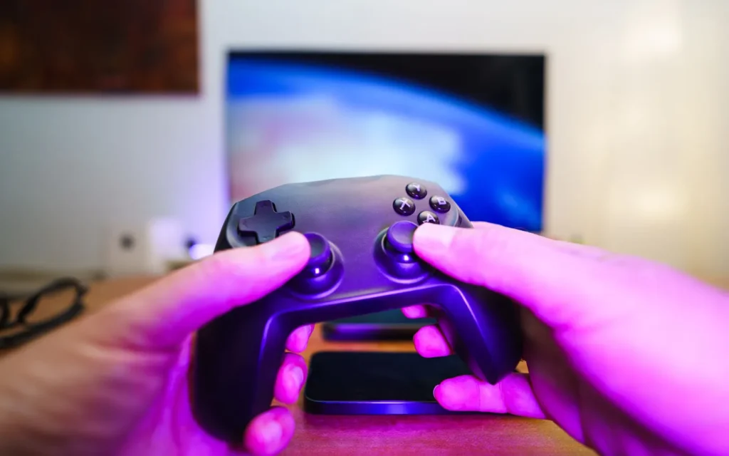 Person holding a wireless game controller while setting up a new gaming account on a TV
