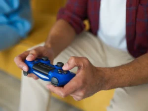 Hands holding a blue wireless game controller